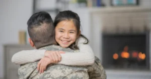 A daughter hugs her military father